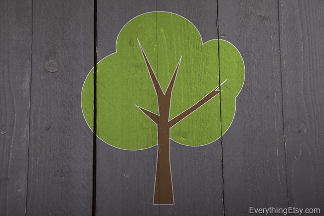 Green tree on black wooden background